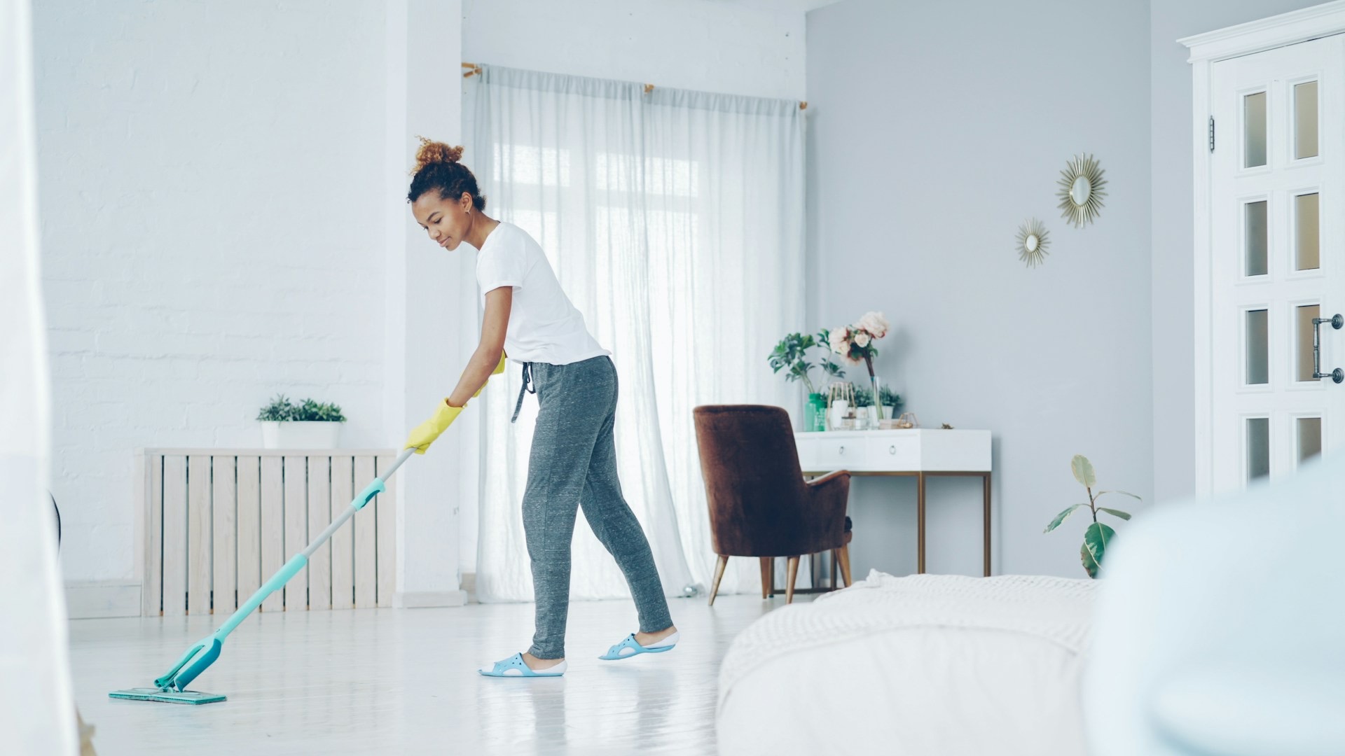 Clean Tech mopping a bright bedroom floor