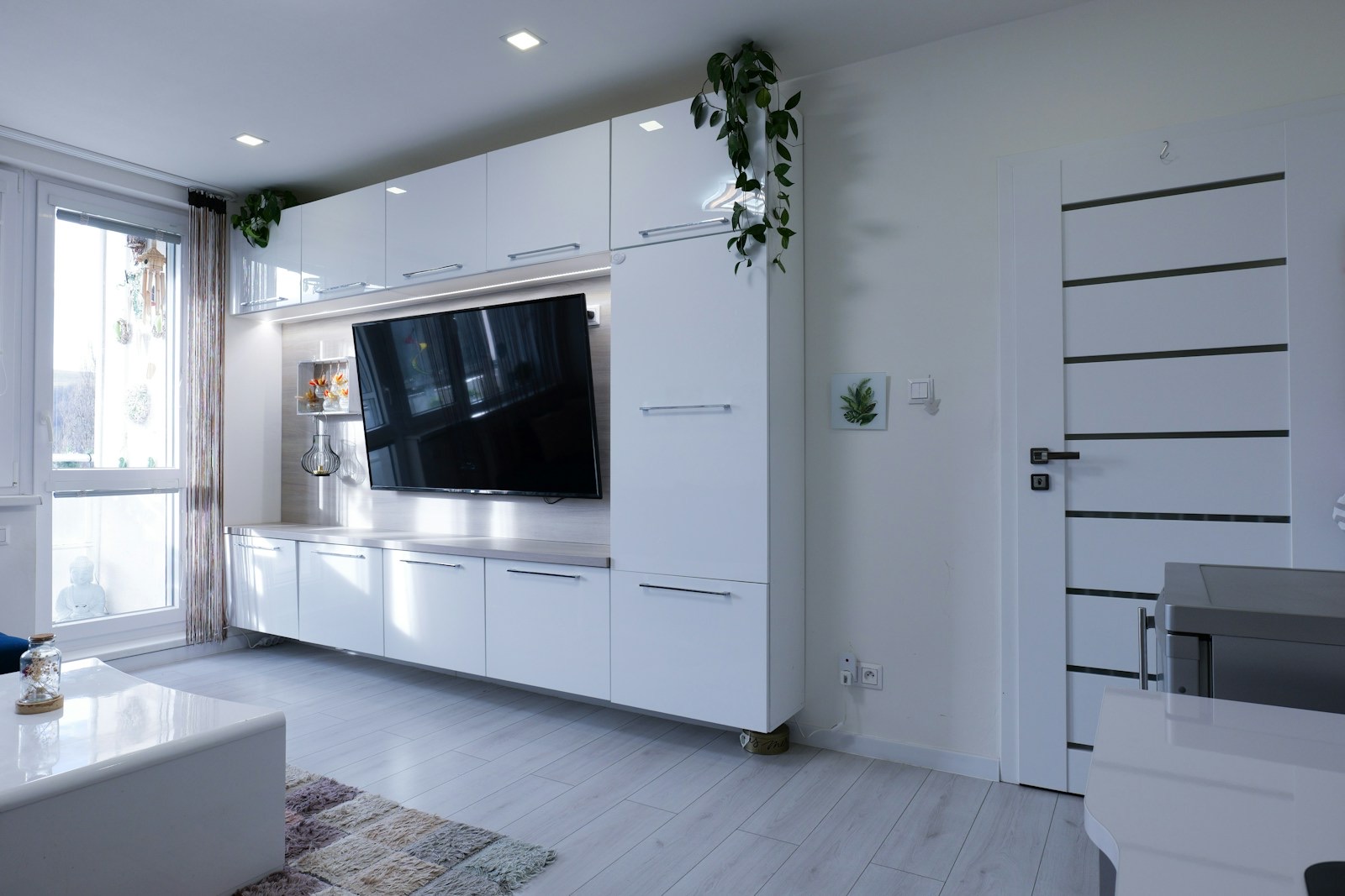 Bright, freshly cleaned modern condo living room with white cabinetry