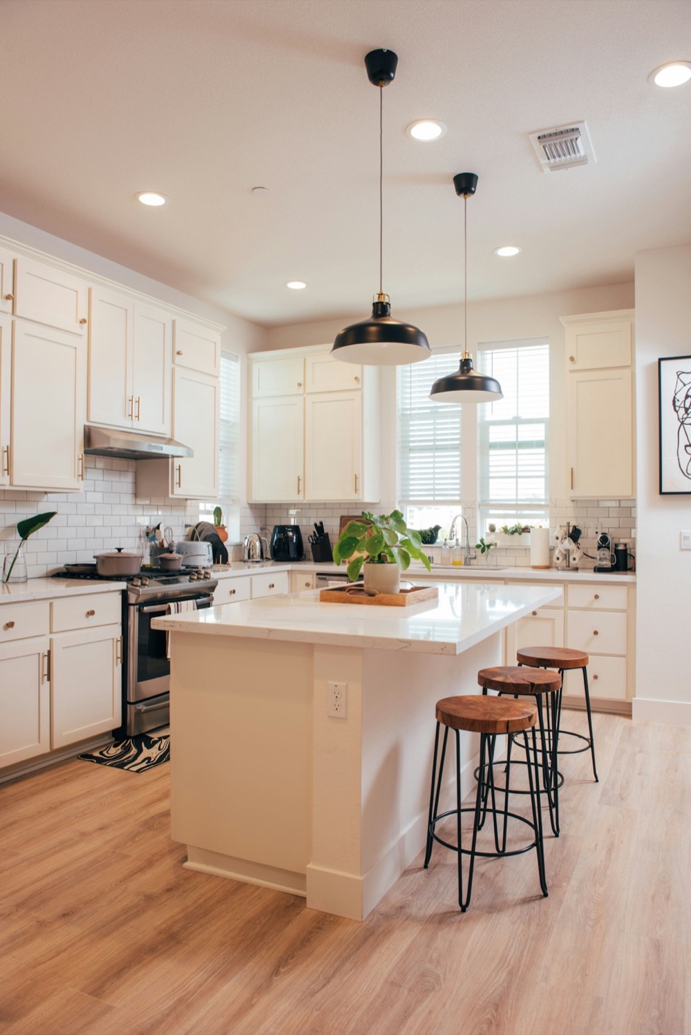 Spotless white condo kitchen with island seating after a recurring clean