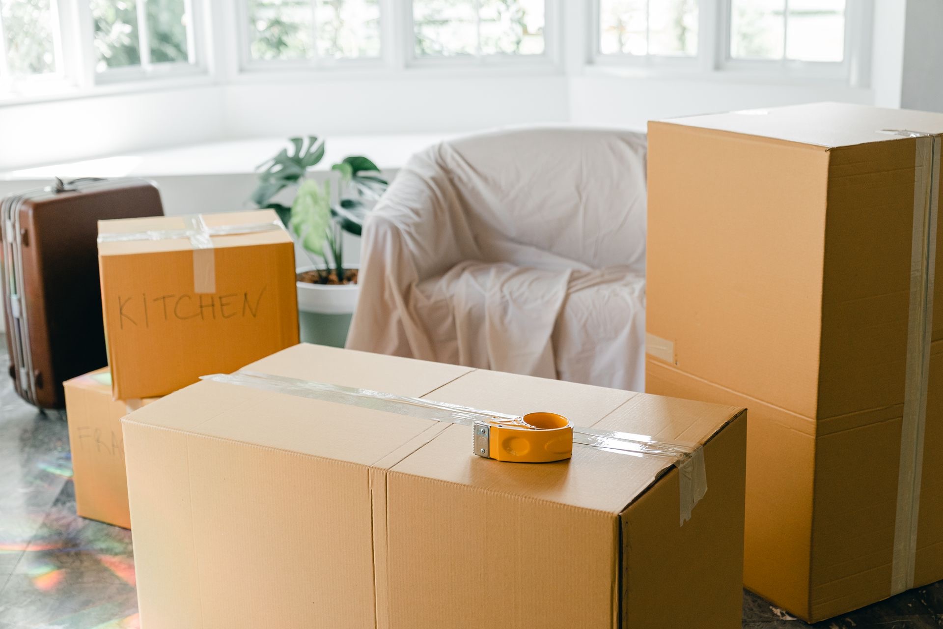 Packed moving boxes in a bright living room before a move-out clean