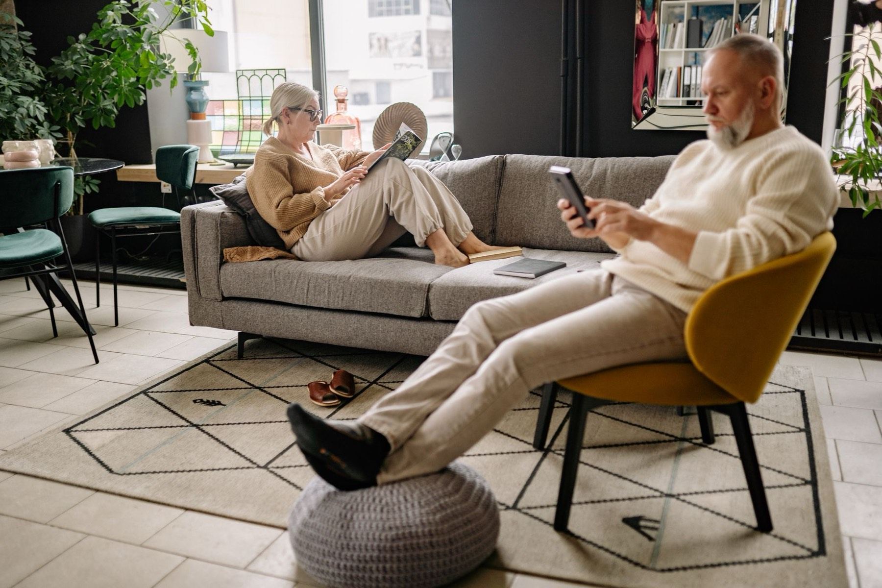 Senior couple relaxing in their bright, freshly cleaned living room