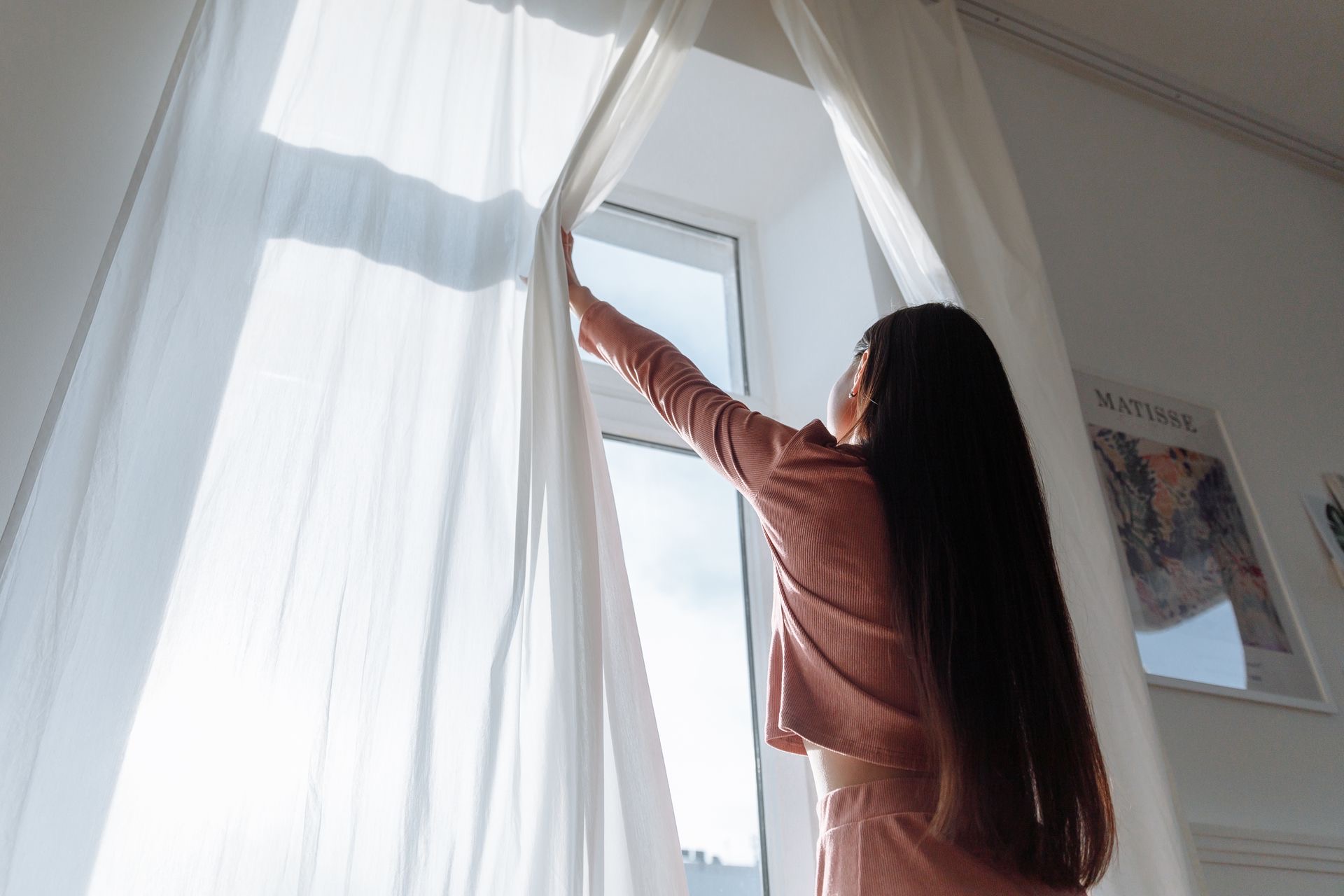 Sheer curtains pulled open to let spring light into a freshly cleaned room