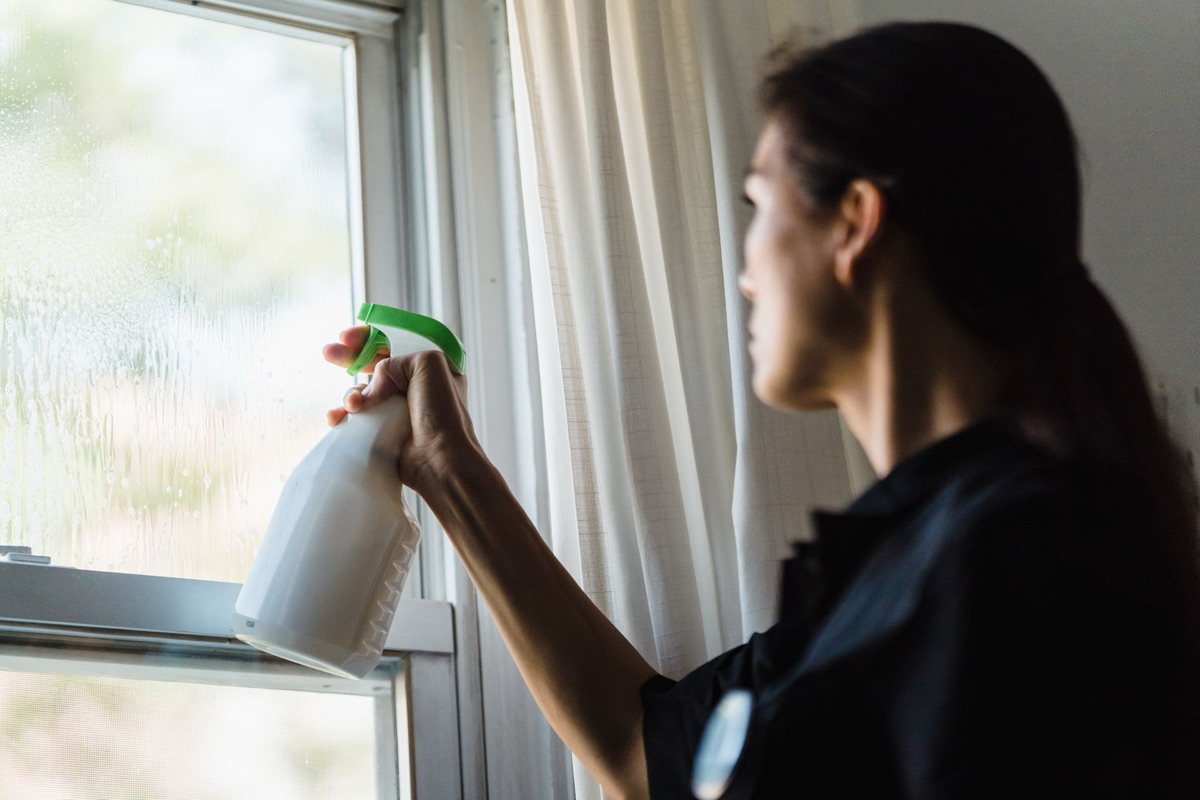 Spraying and washing interior windows during a spring cleaning